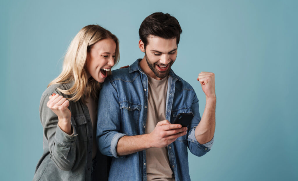 Deux personnes heureuses en découvrant une bonne nouvelle sur leur téléphone