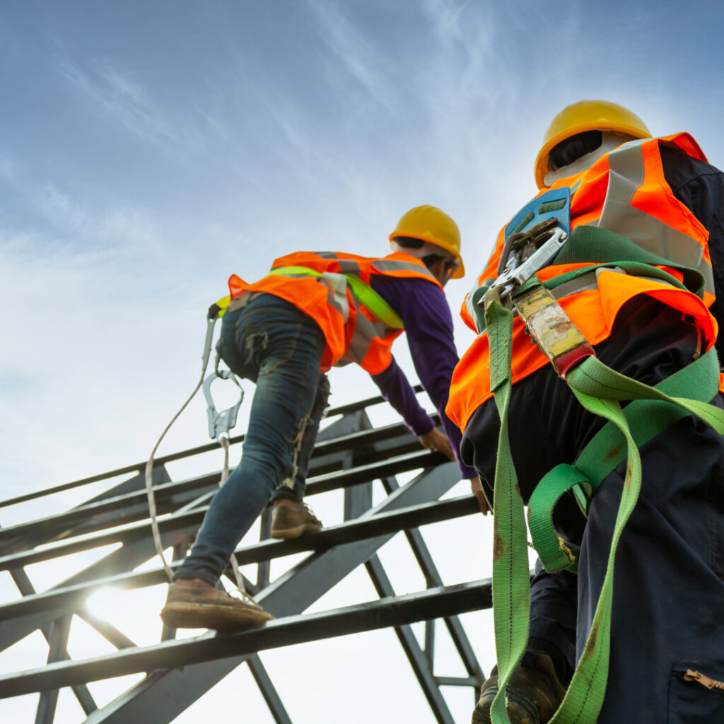Opérateur(rice)s du BTP équipé(e)s de protections pour travail en hauteur